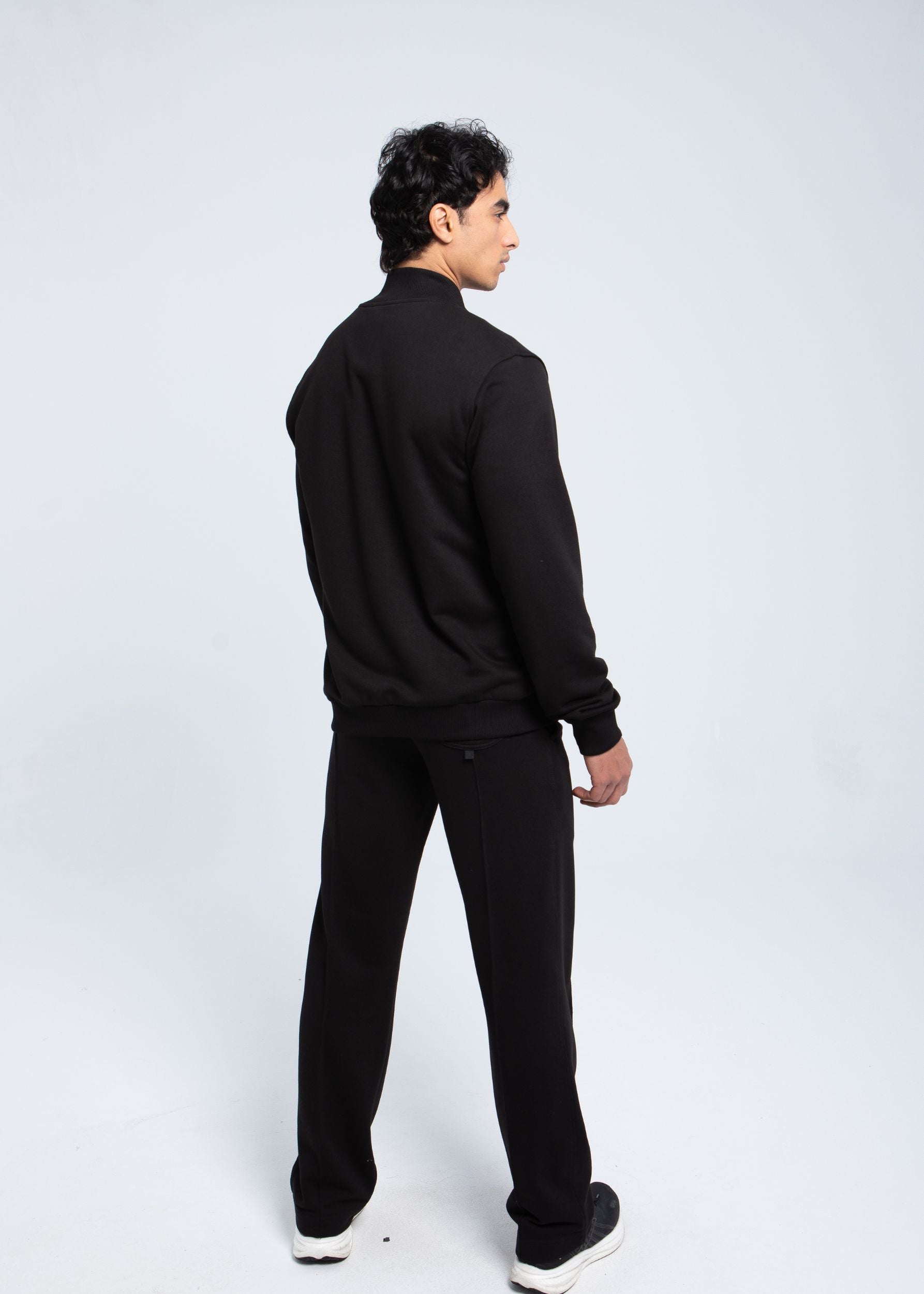 Back angled view of essential full-zip sweatshirt worn by model